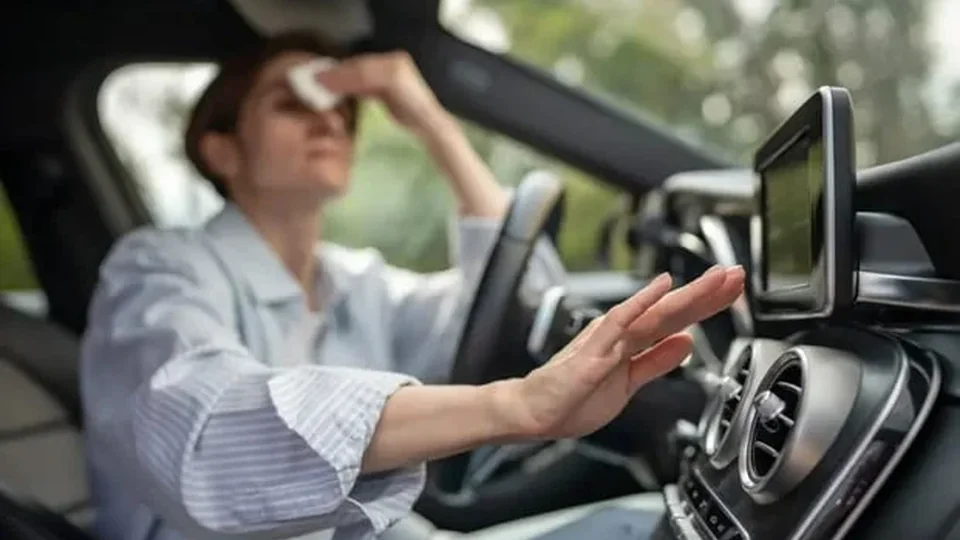 Motorista utilizando o ar-condicionado do veículo