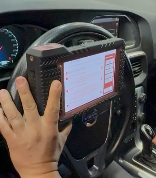 Scanner automotivo sendo utilizado no volante para diagnóstico de injeção eletrônica na CARTOP